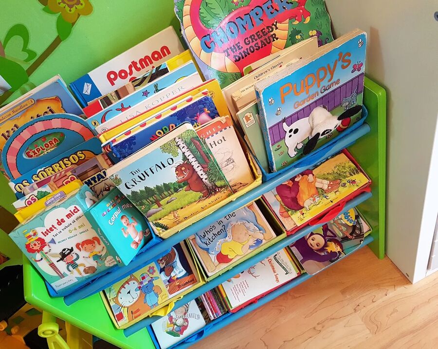 A book rack with children's books in English and Portuguese.